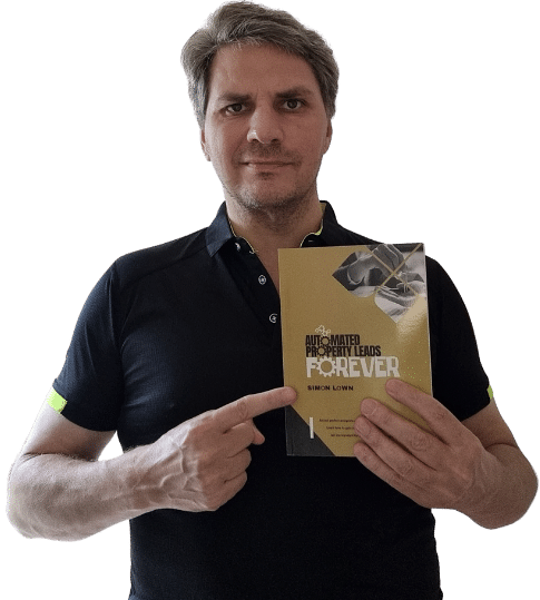 Me holding my book and pointing at the title on the cover