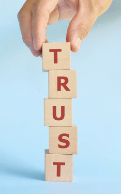 Building the word TRUST out of wooden blocks.