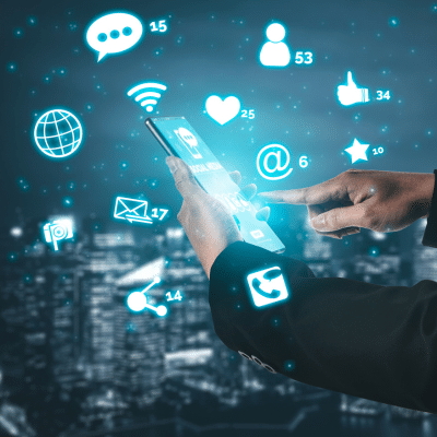 A man holding a phone in a digital cloud of likes, comments, and shares and other images that represent data online.