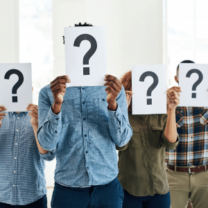 4 people holding an A4 sheet infront of their face with a large questionmark - representing that they are all unknown.