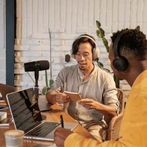 An pair of young men interviewsing and recording for a blog video/ podcast.