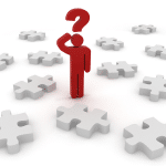Red stick man with a red question mark above his head in the centre of several white puzzle pieces. 