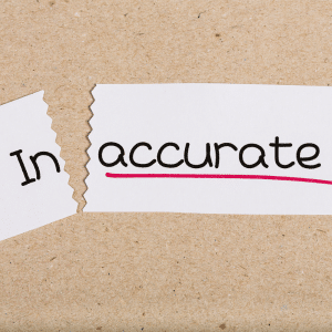 A piece of paper that has cut off the "in" of inaccurate and has underlined accurate in red.