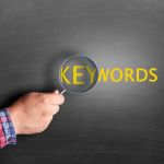 KEYWORDS with a magnifying glas being held over "KEY" and making it larger.
