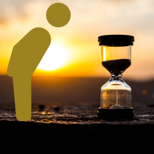 Golden Stick Man bowing (honouring) a sand timer against a sunset backdrop.