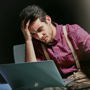 Man a his laptop with head in hand looking lost and stuck.