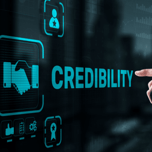 A digital screen with an icon of shaking hands next to the word credibility.

A finger is pointing at the word credibility and there a few other trust symbols.