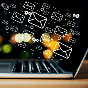 Managing Email with Automation.
A sideview of a laptop on a desk with email and automation cogs flying into the screen.