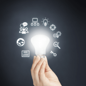 Hand holding a lighbuld surrounded by symbols that suggest thoughts of a leader.